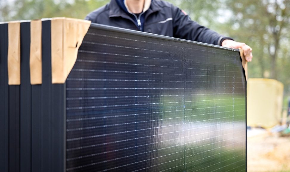 Person holding a set of several new solar panels